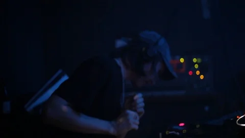Handheld shot of DJ keeps the beat and appears deep in thought at nightclub Stock Footage 114848170