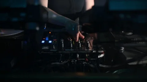 Handheld shot of DJ tweaking knobs on his console Stock Footage 115090394