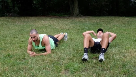 Handheld shot of dog interrupting men training in park Stock Footage 120423205