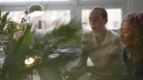 Handheld shot of executives discussing with each other while using laptop Stock Footage 114877867