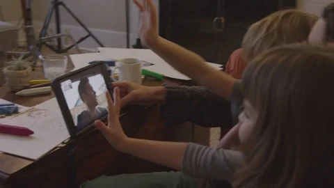 Handheld shot of family on video conference with father in living room at home Stock Footage