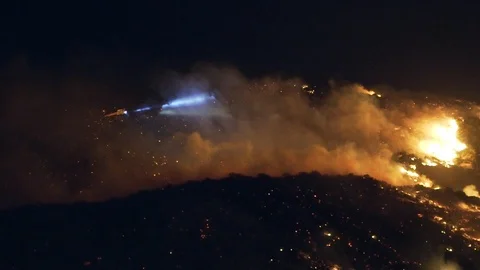 Handheld shot of a fire control copter, extinguishing wild fires, at night Vidéo 121810060