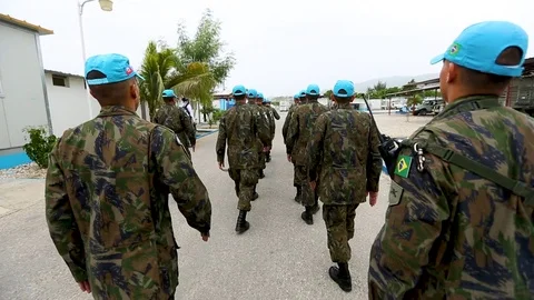 Handheld shot following a marching squad of UN peacekeepers Stock Footage