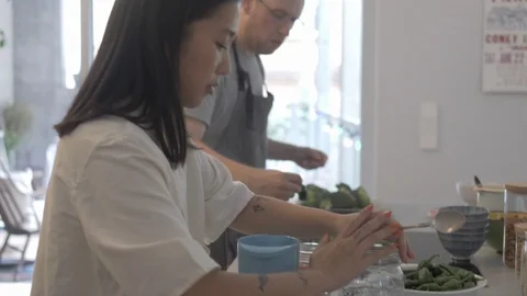 Handheld shot of four friends preparing food together in the kitchen Stock Footage 114842295