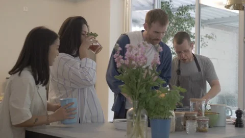 Handheld shot of four friends preparing food together in the kitchen 스톡 동영상 114842296
