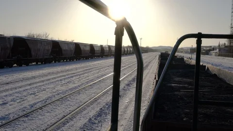 Handheld shot of freight train with empty gondola cars moving around the station Stock Footage 75261705