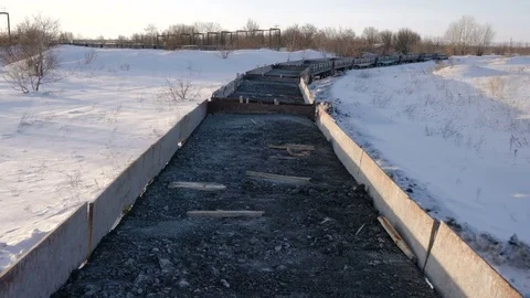 Handheld shot of freight train with empty gondola cars moving along a single Stock Footage 75263924