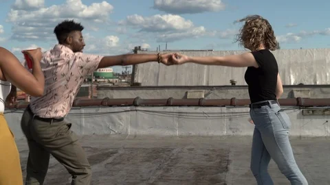 Handheld shot of friends dancing on building terrace Stock Footage 114881009
