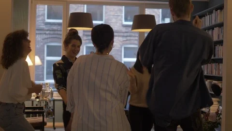 Handheld shot of friends dancing in front of window in library Video stock 114842722