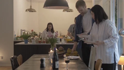 Handheld shot of friends setting the dining table Vídeo Stock 114842429