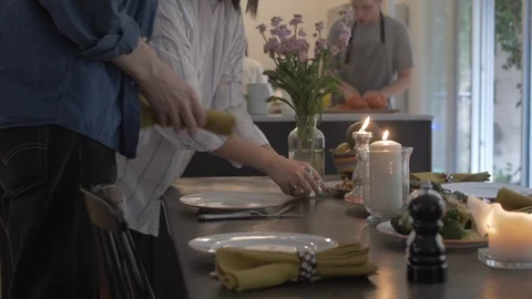Handheld shot of friends setting the dining table Video stock 114842430