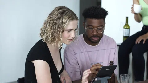 Handheld shot of friends talking with each other while using digital tablet Stock Footage 114866315