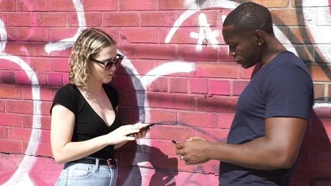 Handheld shot of friends talking with each other while standing by brick wall Stock-Footage 114866385