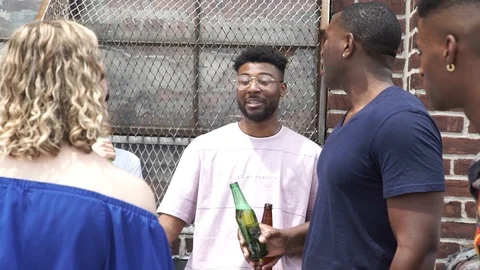 Handheld shot of friends talking while having beer on building terrace Stock Footage 114866289