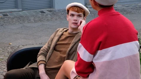 Handheld shot of friends talking while sitting on sofa outdoors Stock Footage 120421545