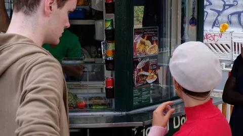 Handheld shot of friends talking while standing by concession stand Stock Footage 120424316