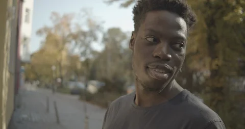 Handheld shot of friends talking while standing on sidewalk Stock Footage 120426654