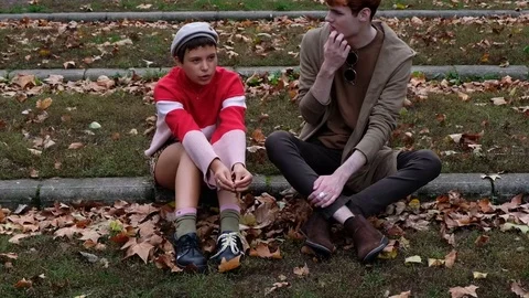 Handheld shot of friends talking while sitting in the park Vídeo Stock 120426704