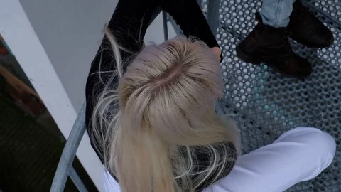 Handheld shot of friends talking while standing on fire escape 스톡 동영상 120428286