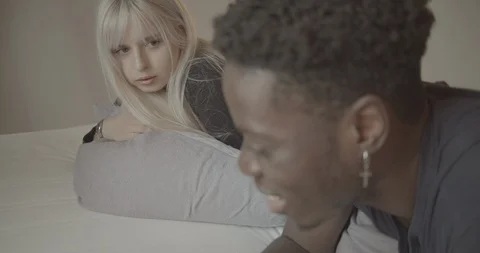 Handheld shot of friends talking while lying on the bed at home Stock Footage 120457852