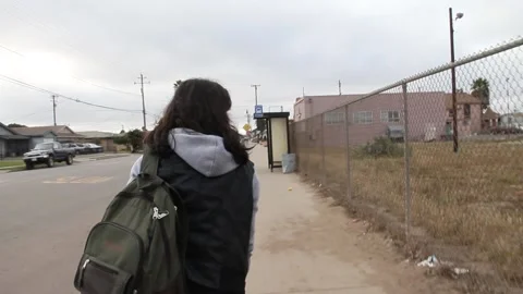 Handheld shot of girl walking down the street of small town Stock Footage 155488403