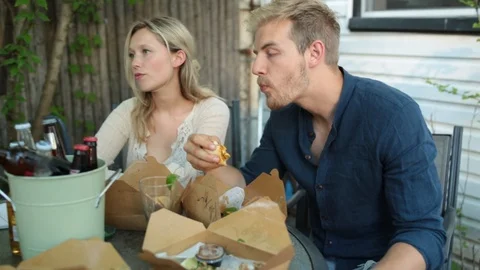 Handheld shot of group of friends talking with each other while having food Stock Footage 114862225