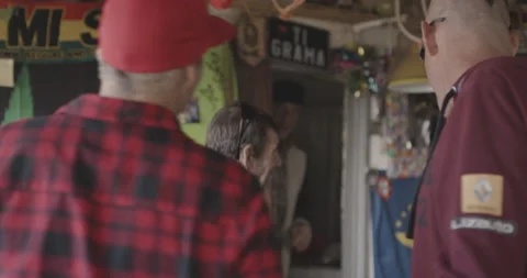 Handheld shot of group of pro surfers entering local store with surfing supplies Stock Footage 160116131
