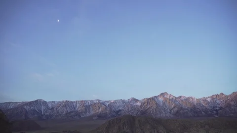 Handheld Shot of Half-Moon Over Mountain Range At Sunrise Stock Footage 90953268