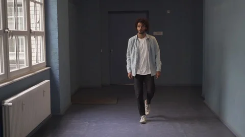 Handheld shot of handsome man walking in corridor Stock Footage 114876918