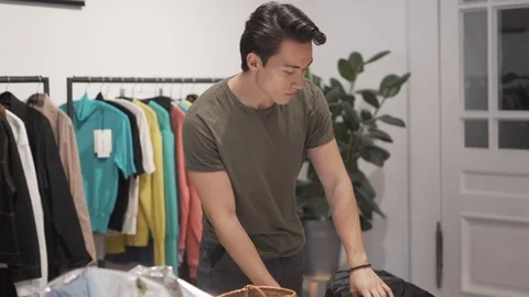 Handheld shot of handsome young man browsing waist bags Stock Footage 114875424
