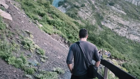 Handheld shot of handsome young man walking on mountain Stock Footage 122396816