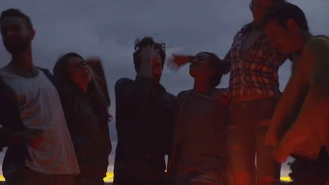 Handheld shot of happy friends singing and dancing at campsite against cloudy Stock Footage