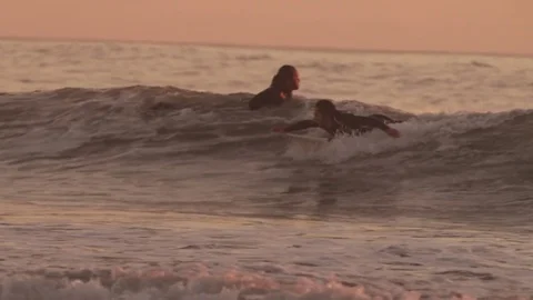 Handheld shot of happy man surfing on sea against sky during sunset Stock Footage