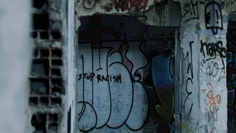 Handheld shot of hole full of graffiti in abandoned warehouse Stock Footage 112896099