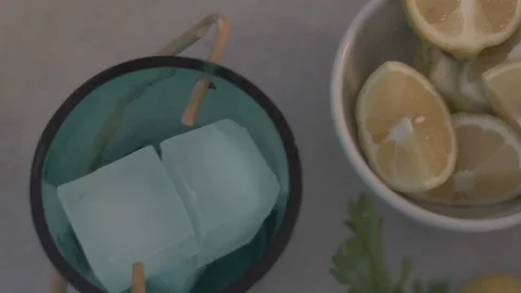 Handheld shot of ice cubes and lemon wedges kept on counter Video stock 114842056