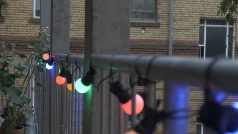 Handheld shot of illuminated string lights at balcony 스톡 동영상 114842706