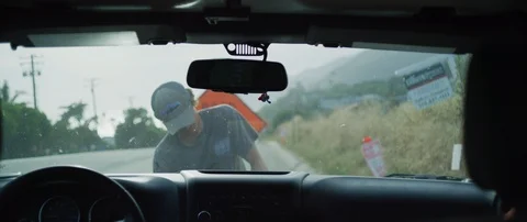 Handheld shot from inside car of young adult man checking under the hood Stock Footage 120287720