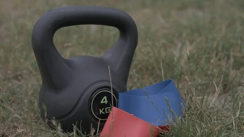 Handheld shot of kettle bell placed on grass Stock Footage 114843793