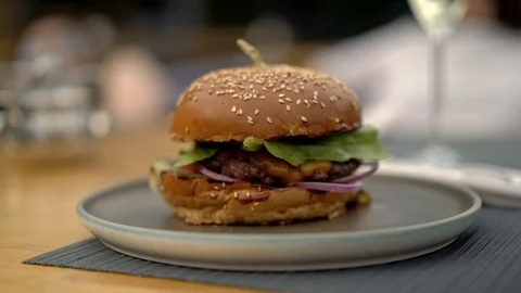 Handheld shot left to right of a fresh burger on a plate Stock Footage 122343068
