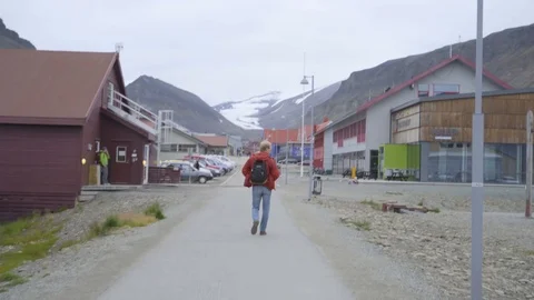 Handheld Shot of Local Man Walking through Longyearbyen, Norway Stock Footage 94536460