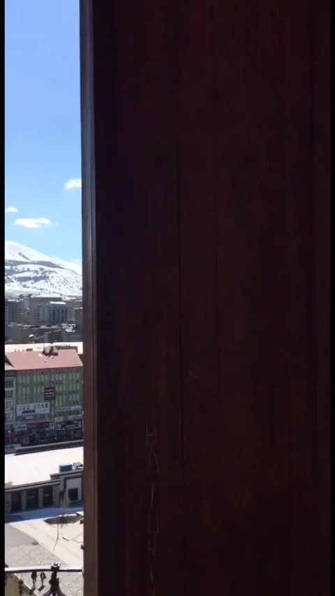 A handheld shot looking out from a dark wooden window frame at a wide panoramic Stock Footage 333376695