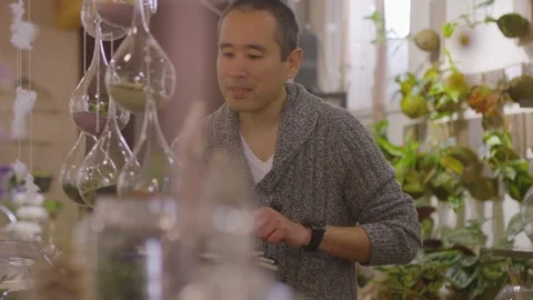 Handheld shot of male worker examining plants at garden center Stock Footage