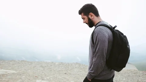 Handheld shot of man with backpack walking on mountain Stock Footage 122519697
