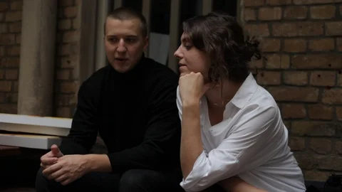Handheld shot of man in black talks with young woman and drinks beer Stock Footage 114848238