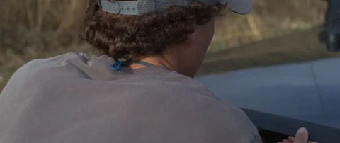 Handheld  shot of man checking under the hood while other man is watching Stock Footage 120287931