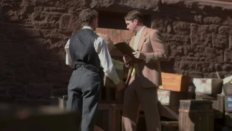 Handheld shot of a man directing delivery person, 1950s, USA - Reenactment Stock Footage 245290501