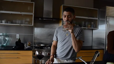Handheld shot of a man drinking water and eating in the kitchen Vídeo Stock 115059990