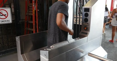 Handheld shot of man getting through turnstile on subway station Stock Footage 120147813