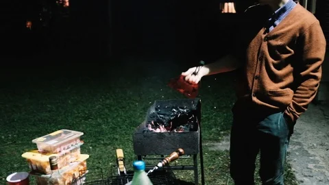 Handheld shot of man igniting barbeque to prepare the food Stock Footage 122518426