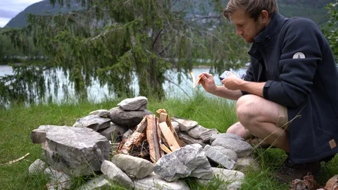Handheld shot a man lighting a bonfire Stock Footage 114883209